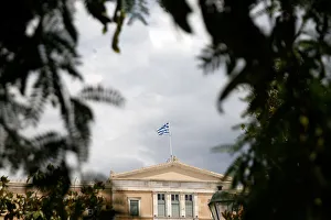 A Greek flag flutters atop the parliament building in Athens A Greek flag flutters atop the parliament building in Athens