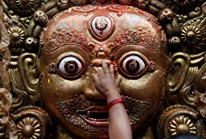 A hand of a devotee is pictured as she sprinkles rice grains while offering prayer on the A hand of a devotee is pictured as she sprinkles rice grains while offering prayer on the