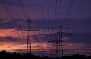 High voltage power lines are seen as the sun sets near the Staudinger coal power plant of High voltage power lines are seen as the sun sets near the Staudinger coal power plant of