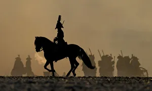 History enthusiast, dressed as a soldier, rides his horse during the re-enactment of History enthusiast, dressed as a soldier, rides his horse during the re-enactment of