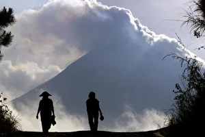 Indonesian farmers are silhouetted in front of Mount Merapi at Srumbung village, near Indonesian farmers are silhouetted in front of Mount Merapi at Srumbung village, near