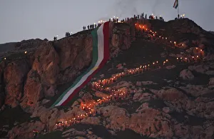 Iraqi Kurdish people carry fire torches up a mountain where a giant flag of Iraq's Iraqi Kurdish people carry fire torches up a mountain where a giant flag of Iraq's