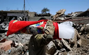 An Iraqi soldier carries a block of ice for his comrades at their positions in Mosul's An Iraqi soldier carries a block of ice for his comrades at their positions in Mosul's