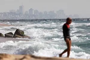 An Israeli man exercises on the beach near the water border line betwen Israel An Israeli man exercises on the beach near the water border line betwen Israel