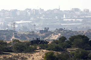 An Israeli military bulldozer is seen on the Israeli side of the border with the northern An Israeli military bulldozer is seen on the Israeli side of the border with the northern