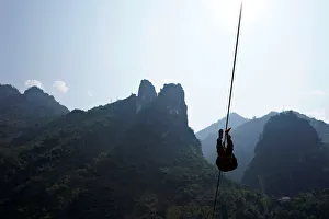 A Lisu man leaves his village on a zipline in Nujiang Lisu Autonomous Prefecture in A Lisu man leaves his village on a zipline in Nujiang Lisu Autonomous Prefecture in