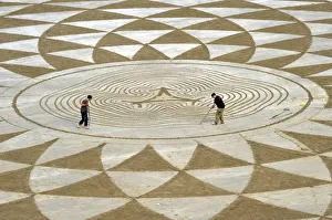 Local artists draw patterns in the sand at low tide on North Beach, Tenby, South Wales Local artists draw patterns in the sand at low tide on North Beach, Tenby, South Wales