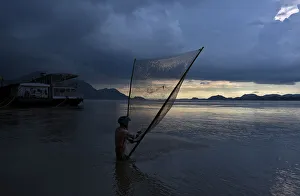 A man catches fish at the banks of the Brahmaputra river in Guwahati A man catches fish at the banks of the Brahmaputra river in Guwahati