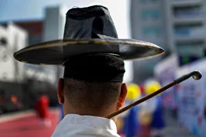 A man in costume waits to perform with others on a side street in Gangneung A man in costume waits to perform with others on a side street in Gangneung
