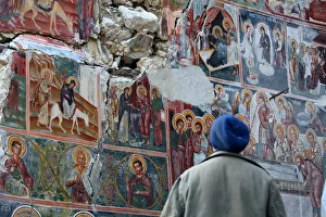 A man looks at a damaged fresco in The Orthodox Church of Saint Athanasios in Leshnica A man looks at a damaged fresco in The Orthodox Church of Saint Athanasios in Leshnica