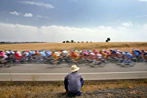Images Dated 30th August 2005: A man looks at a pack of riders cycle during the fifth stage of the Tour of Spain