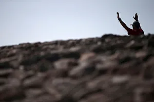 A man raises his arms towards the sun to welcome the spring equinox while he is standing A man raises his arms towards the sun to welcome the spring equinox while he is standing
