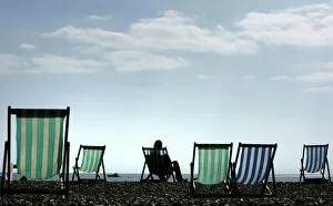 Images Dated 7th April 2007: A man sits on a deck chair in warm Easter weather on Brighton beach in southern England