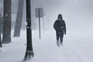 A man struggles against wind and snow during Storm Grayson at the Jersey shore in A man struggles against wind and snow during Storm Grayson at the Jersey shore in
