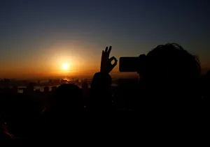 A man takes picture of the first sunrise on New Years Day at Roppongi Hills observation A man takes picture of the first sunrise on New Years Day at Roppongi Hills observation