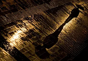 A man walks in the rain along a street in downtown Belgrade A man walks in the rain along a street in downtown Belgrade