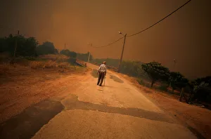 A man walks on the road as the fire approaches Pedreira, near Silves A man walks on the road as the fire approaches Pedreira, near Silves