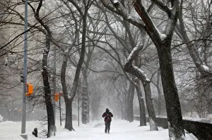 A man walks in the snow next to Central Park along 5th avenue in upper Manhattan during A man walks in the snow next to Central Park along 5th avenue in upper Manhattan during