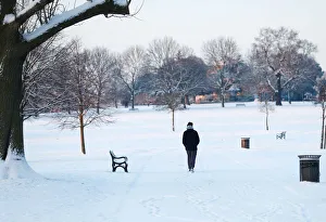 A man walks in a snow covered park in south London A man walks in a snow covered park in south London