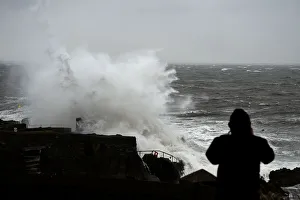 A man watches a large wave break over the Forty Foot diving area as Storm Emma makes A man watches a large wave break over the Forty Foot diving area as Storm Emma makes