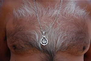 A man wears a pendant of the traditional Virgen del Carmen one day before arrival of A man wears a pendant of the traditional Virgen del Carmen one day before arrival of