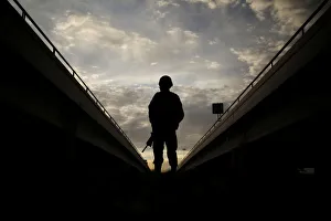 A member of the Mexican National Guard stands near the border fence between Mexico and the U A member of the Mexican National Guard stands near the border fence between Mexico and the U