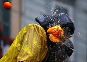 A member of a rival team is hit by an orange during an annual carnival battle in the A member of a rival team is hit by an orange during an annual carnival battle in the
