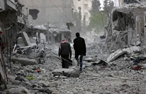 Men walk through debris in the center of Afrin Men walk through debris in the center of Afrin