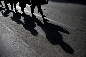 Military policemen cast their shadows as they march toward a protest to mark Military policemen cast their shadows as they march toward a protest to mark