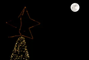 A full moon rises in the sky over a Christmas tree in Beirut, Lebanon A full moon rises in the sky over a Christmas tree in Beirut, Lebanon