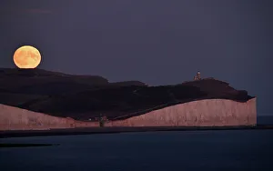 The moon is seen rising behind the Seven Sisters Cliffs at Birling Gap in East Sussex The moon is seen rising behind the Seven Sisters Cliffs at Birling Gap in East Sussex