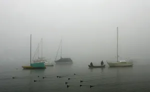Moored boats are pictured on a foggy autumn morning at lake Ammersee in Herrsching Moored boats are pictured on a foggy autumn morning at lake Ammersee in Herrsching
