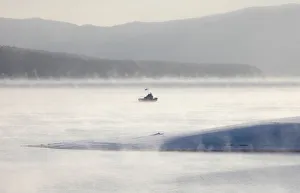 A motor boat sails through a frosty fog across the Yenisei River outside Krasnoyarsk A motor boat sails through a frosty fog across the Yenisei River outside Krasnoyarsk