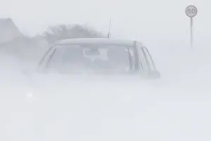 A motorist drives through snow blown from fields near Buxton in central England A motorist drives through snow blown from fields near Buxton in central England