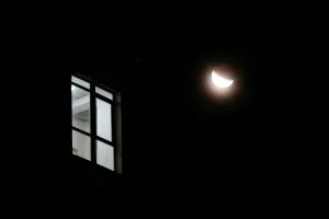 Partial Lunar Eclipse Prints: The light shines in the window of a building during a partial lunar eclipse in