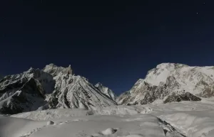 Prints of The worlds second largest mountain, the 8, 611 meter high K2 (seen in the distance), and the 8, 051 meter high Broad Peak (R), are illuminated by the moon at Concordia Pakistan Prints: Print of K2 illuminated by the moon, a 8611 meter high mountain in Pakistan