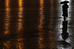 A nun shelters under an umbrella as she makes her way through Saint Peters Square on a A nun shelters under an umbrella as she makes her way through Saint Peters Square on a