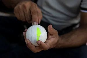 A Pakistani man living in Greece wraps a tennis ball in electrical tape before a A Pakistani man living in Greece wraps a tennis ball in electrical tape before a