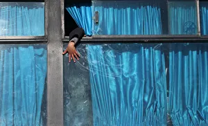 A Palestinian boy puts his hand out of a bus window as he waits with his family to cross A Palestinian boy puts his hand out of a bus window as he waits with his family to cross