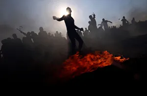 Palestinian demonstrators hurl stones at Israeli troops during a protest at the border Palestinian demonstrators hurl stones at Israeli troops during a protest at the border
