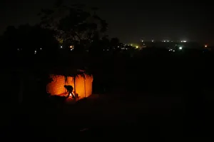 A Palestinian man ignites a fire at his makeshift shelter during a power cut in the A Palestinian man ignites a fire at his makeshift shelter during a power cut in the