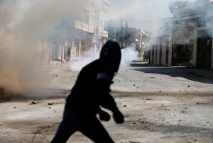 A Palestinian protester runs from tear gas during an Israeli raid in Deir Meshaal village A Palestinian protester runs from tear gas during an Israeli raid in Deir Meshaal village