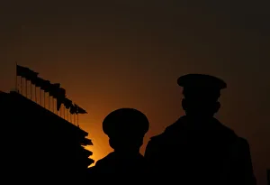 Paramilitary policemen stand guard at Tiananmen Square as the sun sets over the Great Paramilitary policemen stand guard at Tiananmen Square as the sun sets over the Great