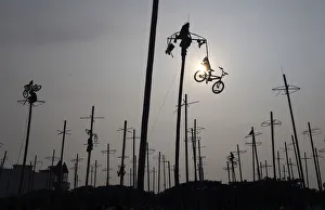 A participant pulls down a bicycle from the top of a greased pole during the Panjat A participant pulls down a bicycle from the top of a greased pole during the Panjat