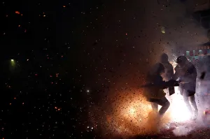 Participants wearing motorcycle helmets get sprayed with firecrackers Participants wearing motorcycle helmets get sprayed with firecrackers