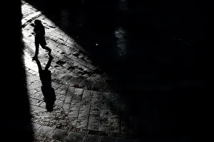 A pedestrian walks through Quincy Market on a warm winter afternoon in downtown in Boston A pedestrian walks through Quincy Market on a warm winter afternoon in downtown in Boston