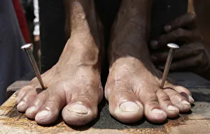 A penitents feet are nailed to a wooden cross on Good Friday in the town of San Juan in A penitents feet are nailed to a wooden cross on Good Friday in the town of San Juan in