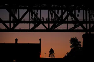 People climb the Sydney Harbour Bridge at sunset, in Sydney People climb the Sydney Harbour Bridge at sunset, in Sydney