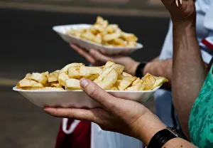 People eat chips whilst walking along the promenade at the British holiday resort People eat chips whilst walking along the promenade at the British holiday resort
