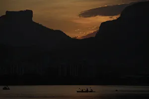 People paddle their canoe at Rodrigo de Freitas Lagoon as the sun sets in Rio de Janeiro People paddle their canoe at Rodrigo de Freitas Lagoon as the sun sets in Rio de Janeiro